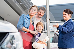 Car dealer advising family on buying auto