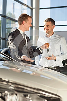 Car dealer giving client keys