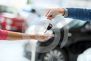 Car dealer giving keys to woman