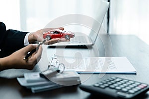 Car dealer provides advice on loans, insurance details, car rental information, delivers car with keys after the rental contract