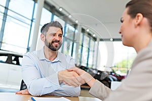 Car dealer shaking hand with a buyer