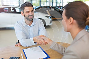 Car dealer shaking hand with a buyer