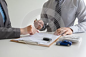 Car dealership provides advice about insurance details and car rental information and delivers the keys after signing the rental