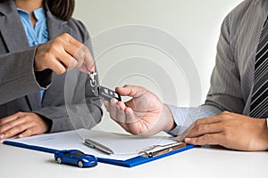 Car dealership provides advice about insurance details and car rental information and delivers the keys after signing the rental