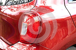 Car detail series: Close-up of the red tail light, parked under the shadow of a tree