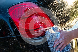 Car detailer washing auto with soap photo