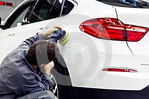 Car detailing - Hands with orbital polisher in auto repair shop photo