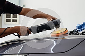 Car detailing - Male mechanic holding car polishing machine. Auto industry, car polishing and painting and repair shop