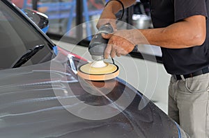 Car detailing - Male mechanic holding car polishing machine. Auto industry, car polishing and painting and repair shop