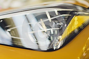 Car detailing series: Clean headlights of yellow sports car.