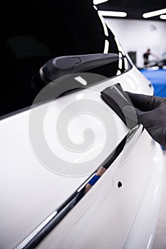 Car detailing studio worker applying car ceramic coating