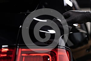 Car detailing studio worker applying ceramic coating