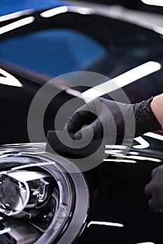 Car detailing studio worker applying car ceramic coating