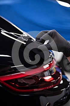 Car detailing studio worker applying car ceramic coating