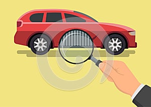 Car diagnostic concept. Hand with magnifying glass inspecting a car