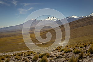 Car on dirt road crossing Atacama desert, volcanic arid landscape in Chile