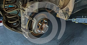 Car disc brake system. Car suspension in process of new tire replacement at garage workshop. Car disc brake mechanic check and