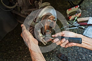 Car disk brake pad replacement service by hand of mechanic man. Auto mechanic repairing the breaks of a car