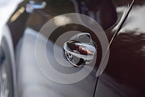 car door handle with keyless entry. the car body is dark in color. black car body. driver's door of a modern premium car