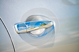 A car door handle, reflections