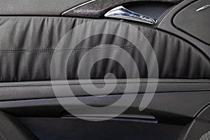 Car door trim with black leather upholstery on a white isolated background for repair and replacement in a car service. Spare