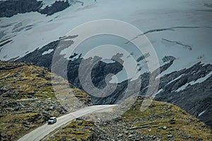 Car on the Dramatic Alpine Road with Glaciers