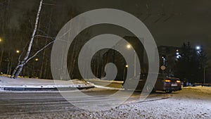 Car drifts on snow-covered road in night city. Action. Stylish new car turns sharply on turn on snow-covered road in