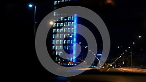 The car drive against the background of building. Evening night time. Slow motion capture blue light