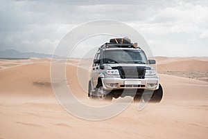 Car driven through sand dunes in Gobi desert