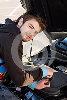 Car driver examining the car's engine