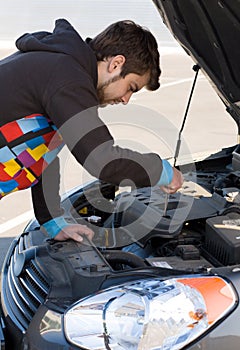 Car driver examining the car's engine