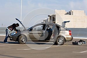 Car driver examining the car's engine