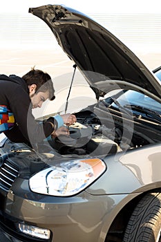 Car driver examining the car's engine