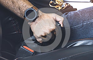 Car driver pulling handbrake lever