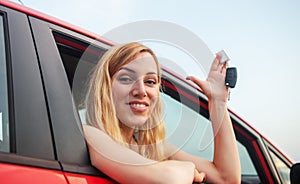 Car driver woman smiling showing new car keys and car.