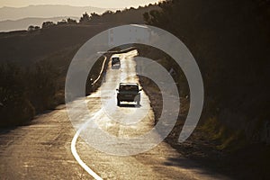 Car drives along a road flooded with sunlight.