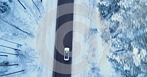 Car drives on a winter road. Winter road, trees and bushes covered with snow.