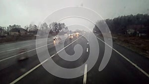 The car is driving along the highway, there are drops on the windshield.