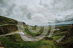 Car driving along a trail on Skie island in Scotland captured under a grey cloudy sky