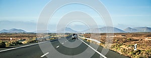 Car driving away to mountains in Canary Island desert
