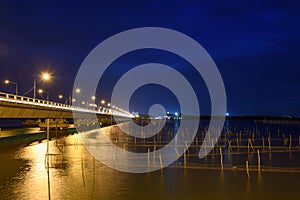 Car driving on bridge with traditional fishing in lake