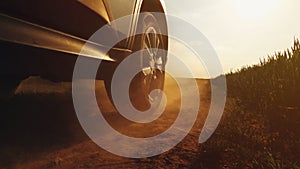 Car driving on countryside dirt road, low angle view