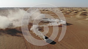 Car is driving in the desert. Dubai, drone camera