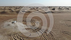 Car is driving in the desert. Dubai, drone camera