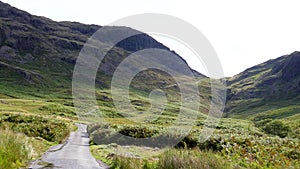 Car driving down from Hardknott Pass in Lake District mountains