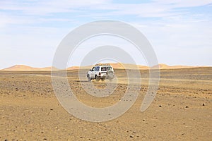 Car driving in the Erg Chebbi desert in Morocco photo