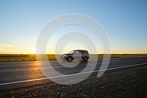 Car driving fast on intercity road at sunset. Highway traffic in evening