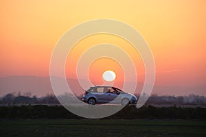 Car driving fast on intercity road at sunset. Highway traffic in evening