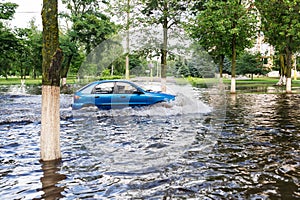 The car driving on a flooded road during a flood caused by heavy rain