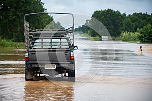 Car driving on flooded road with Flood water flow through the road after heavy winds and storm surges